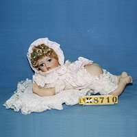 Sleeping baby doll, lovely face & curly blond hair, w/a pillow.